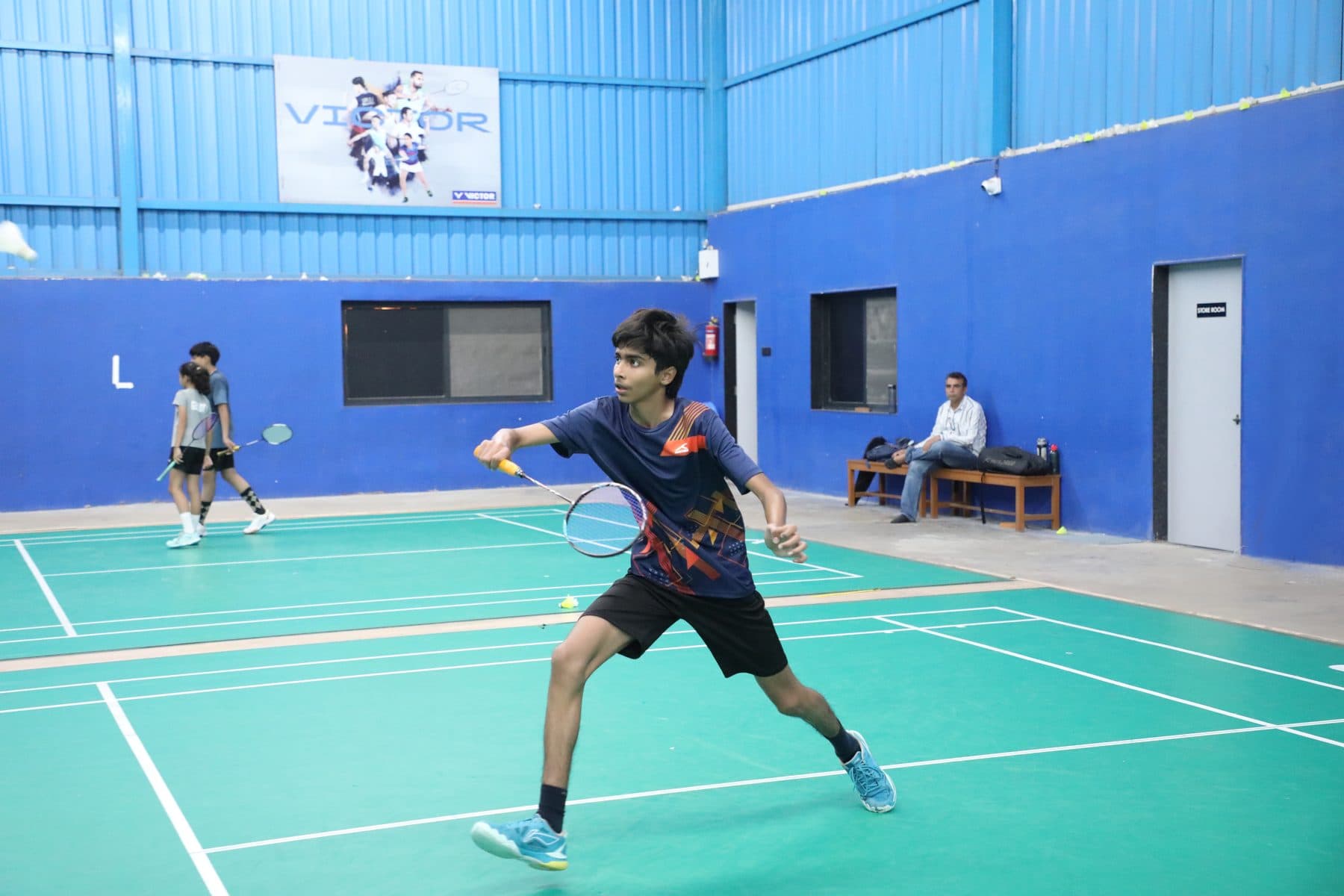 Player returning a shot at Axon Badminton Academy Palanpur